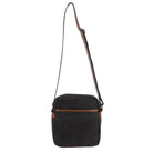 Black crossbody bag with brown leather accents on a white background